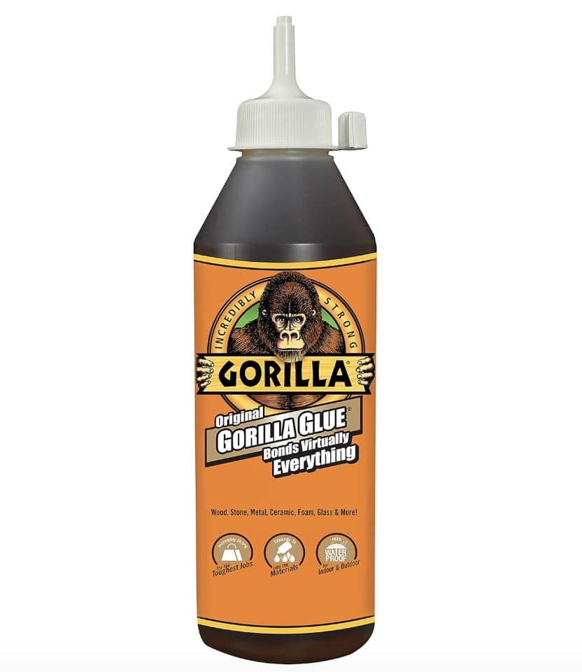 A bottle of Original Gorilla Glue with a brown label featuring a gorilla logo. The text boasts "Bonds Virtually Everything," perfect for projects with materials like wood, stone, metal, ceramic, foam, glass, and more. Ideal for crafting an air dry clay house. The gray cap has a precision nozzle.